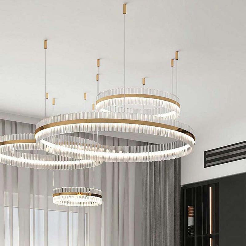 Elegant chandelier featuring multiple overlapping LED rings suspended from a ceiling, casting soft, ambient illumination in a modern living area.